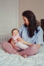 Asian mother kissing touching embracing her cute adorable newborn infant baby. Royalty Free Stock Photo