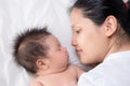 Asian mother lays on bed with newborn baby Royalty Free Stock Photo