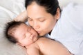 Asian mother lays on bed with newborn baby Royalty Free Stock Photo