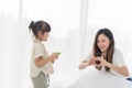 Asian mother and little girl daughter child blowing soap bubbles in the living room, have fun together in a cozy home, happy Royalty Free Stock Photo