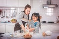 Mother and little girl with messy hand cooking bakery on kitchen counter at home Royalty Free Stock Photo