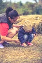 Asian mother and lovely daughter in her winter warm clothing playing at farm. Outdoors Royalty Free Stock Photo