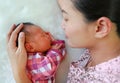 Asian mother lying with her son on white fur background. Close-up of baby and mom Royalty Free Stock Photo