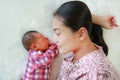 Asian mother lying with her son on white fur background. Close-up of baby and mom Royalty Free Stock Photo