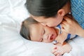 Asian Mother is playing and kissing her little baby boy on the bed Royalty Free Stock Photo