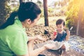 Asian mother playing plastic trumpet pipe with her daughter. Vintage tone. Royalty Free Stock Photo