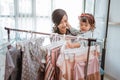 asian mother purchasing a clothes while shopping with her toddler baby Royalty Free Stock Photo