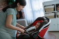 Asian mother putting baby into seat Royalty Free Stock Photo