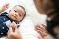 Asian mother`s hand holding newborn baby fingers with love and care.