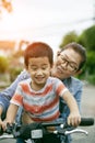 Asian mother and son practice to riding bicycle in public park Royalty Free Stock Photo