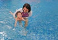 Asian mother take little Asian baby boy in swimming class. Happy toddler enjoying swim in pool with mom