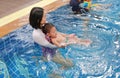Asian mother take little Asian baby boy in swimming class. Happy toddler enjoying swim in pool with mom Royalty Free Stock Photo