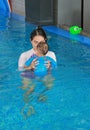 Asian mother teaching baby boy in swimming pool Royalty Free Stock Photo