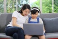 Asian mother teaching her daughter to learn from online class using laptop for homeschooling and education Royalty Free Stock Photo