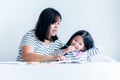 Asian mother is teaching a 6 year old daughter to learn to write and read Royalty Free Stock Photo
