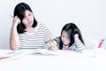 An Asian mother is teaching a 6 year old daughter to learn to write and read Royalty Free Stock Photo