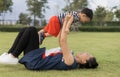 An Asian mother and toddler son 1-year-old are playing, laugh, and relax together in the garden on a cloudy day