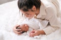 Asian mother touch head of her newborn baby with emotion of careful and love on white bed