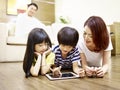 Asian mother and two children using digital tablet together Royalty Free Stock Photo