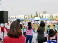 Asian mother watching her children participating in a sport day event at school