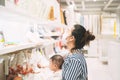 Asian mother wearing a mask holds her baby shopping in a department store. Royalty Free Stock Photo