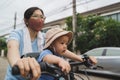 Asian Mother wearing protective face mask and her little baby son riding bicycle Royalty Free Stock Photo