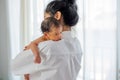 Asian mother with white shirt place upon the shoulder of little newborn baby after give milk and the baby look sleepy Royalty Free Stock Photo