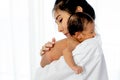 Asian mother with white shirt place upon the shoulder of little newborn baby after give milk and the baby look sleepy Royalty Free Stock Photo