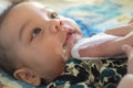 Asian mother is wiping her baby`s face after infant baby boy vomiting with soft sunbeam. people and family lifestyle concept Royalty Free Stock Photo