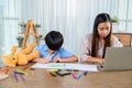 Asian mother work home together with son. Mom and kid drawing picture and color painting art. Woman lifestyle and family Royalty Free Stock Photo