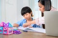 Asian mother work home together with son. Mom and kid drawing picture and color painting art. Woman lifestyle and family Royalty Free Stock Photo