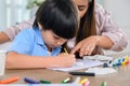 Asian mother work home together with son. Mom and kid drawing picture and color painting art. Woman lifestyle and family Royalty Free Stock Photo
