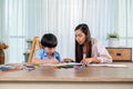 Asian mother work home together with son. Mom and kid drawing picture and color painting art. Woman lifestyle and family Royalty Free Stock Photo
