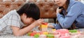 Asian mother work home together with son. Mom and kid play color wooden block. Child creating building toy. Royalty Free Stock Photo