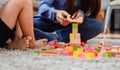 Asian mother work home together with son. Mom and kid play color wooden block. Child creating building toy. Royalty Free Stock Photo