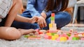 Asian mother work home together with son. Mom and kid play color wooden block. Child creating building toy. Royalty Free Stock Photo