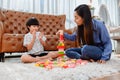 Asian mother work home together with son. Mom and kid play color wooden block. Child creating building toy. Royalty Free Stock Photo