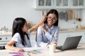 Asian mother working from home with child, daughter making noise and disturb woman at work