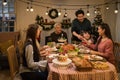 an asian multi-generational family joyfully gathers around a festive dinner table, celebrating christmas or thanksgiving, sharing Royalty Free Stock Photo