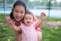 Asian mum and little child - young happy and beautiful Chinese woman playing on city park with adorable and cheerful baby girl in Royalty Free Stock Photo