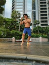 Asian muscular strong active man Tdoing thai boxing in a park