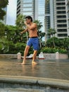 Asian muscular strong active man Tdoing thai boxing in a park