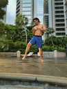 Asian muscular strong active man Tdoing thai boxing in a park