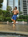 Asian muscular strong active man Tdoing thai boxing in a park