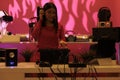 Asian musician with headphones mixing electronic sounds with techno performing music in front of crowd