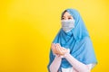 Woman wear hijab and face mask she henna decorated hands praying