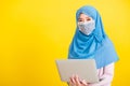 Woman wear hijab and face mask protective to prevent coronavirus she holding laptop Royalty Free Stock Photo