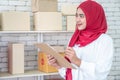 Asia Muslim businesswoman, SME owners inspect products in stock.