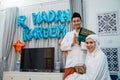 Asian Muslim couple with gestures wishing happy ramadan at home