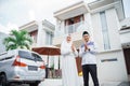 Asian Muslim couple with hand gestures saying Eid al-Fitr